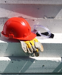 安全帽和工作手套擺放在灰色水泥階梯上。
